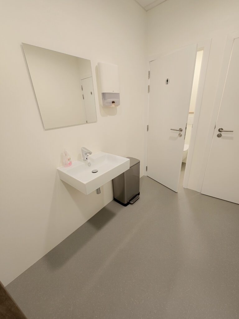 Duurzame en onderhoudsvriendelijke PU gietvloer en wandafwerking voor een professionele sanitaire ruimte.