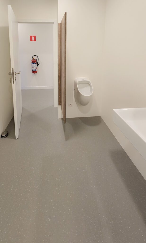 Onderhoudsvriendelijke en stijlvolle sanitaire ruimte met waterdichte gietvloer en strakke uitstraling.