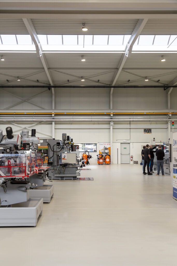 Plaatsing van twee lagen epoxycoating op polybetonvloer in de toonzaal van Crispyn, Maldegem
