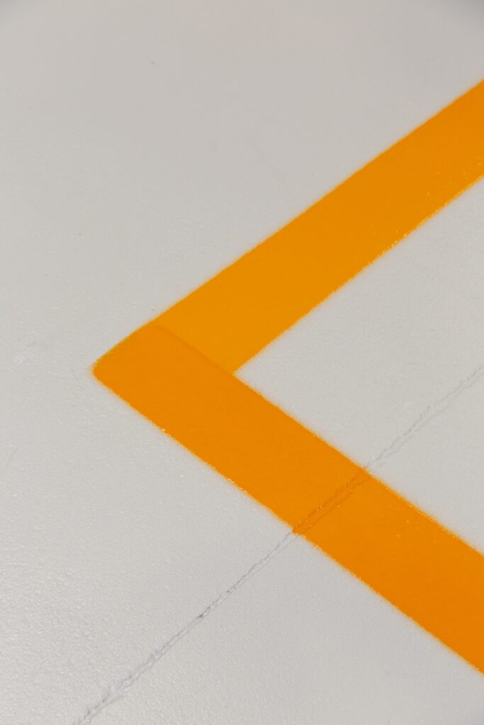 eloranje belijning rond demonstratiezone in toonzaalvloer met epoxy- en PU-afwerking

