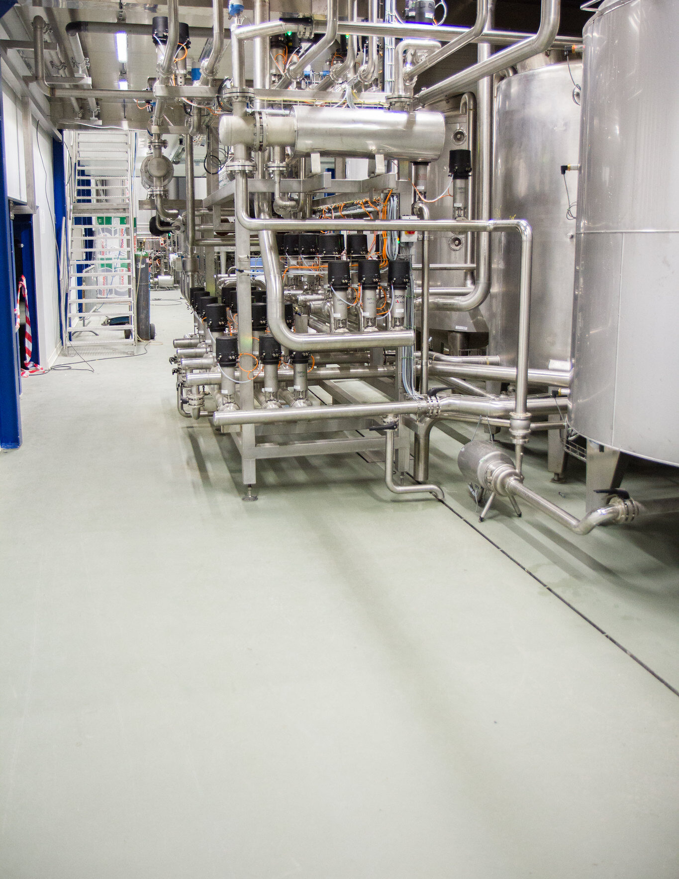 Hygiënische Ucrete-vloer met geïntegreerde afwatering rond ketels in melkverwerkende fabriek